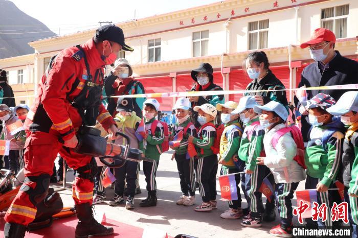 圖為消防指戰(zhàn)員為學(xué)生講解、演示先進(jìn)救援裝備?！≮w琳 攝