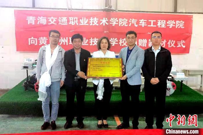 圖為李富香(中)代表學(xué)校為州縣技校捐贈器材。(資料圖) 青海省教育廳供圖