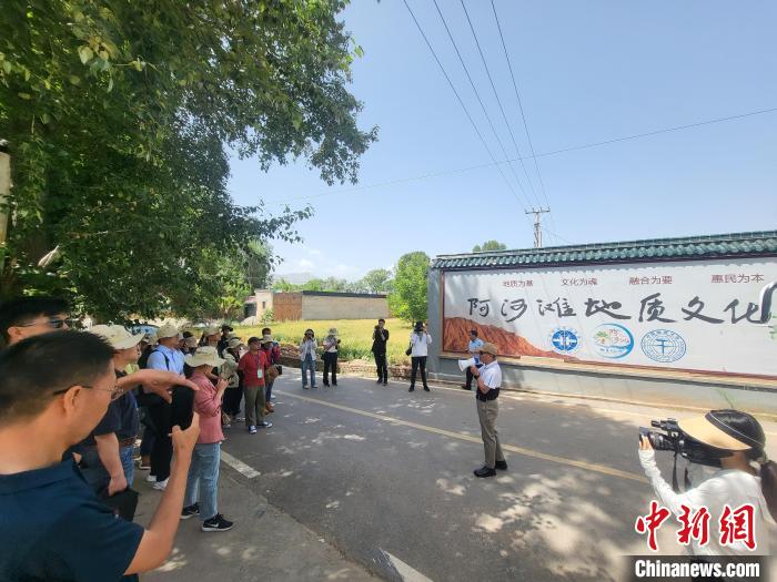 圖為中國(guó)地質(zhì)大學(xué)(北京)教授張緒教介紹村落情況?！『衍?攝