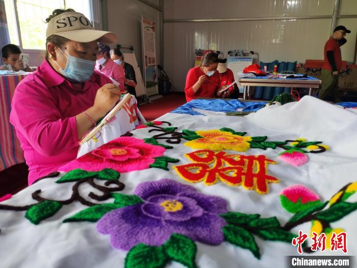 圖為婦女制作青繡?！?zhí)砀?攝