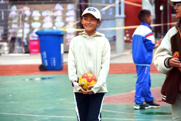 在高原上教孩子們打手球，“慢慢兒來，甭著急！”