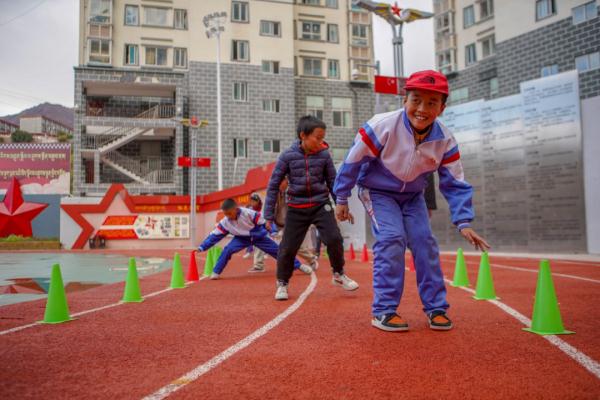 在高原上教孩子們打手球，“慢慢兒來，甭著急！”