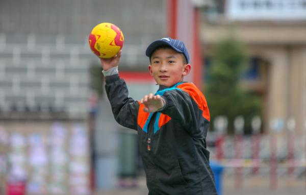 在高原上教孩子們打手球，“慢慢兒來，甭著急！”