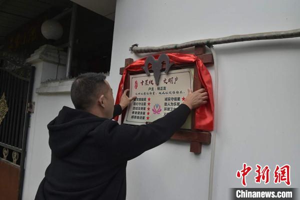 桂溪鎮(zhèn)渭溝村政府工作人員為“十星級(jí)文明戶”掛上牌匾?！钣?攝