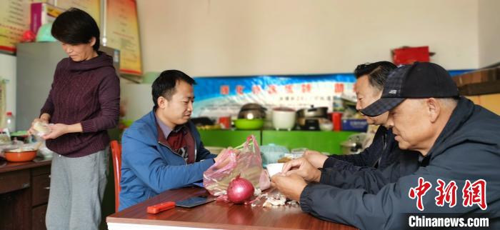 圖為扶貧路上“臨時一家人”準備午餐。　魏建軍 攝