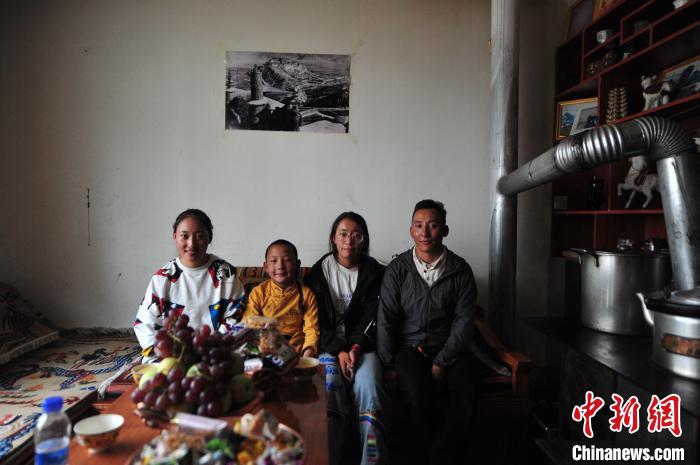 圖為8月12日，2018年7月從距那曲市色尼區(qū)城區(qū)那曲鎮(zhèn)90千米外的古露鎮(zhèn)當(dāng)桑村搬遷至城區(qū)的旦增(右一)與家人在80多平方米的新家合影(資料圖)?！垈?攝