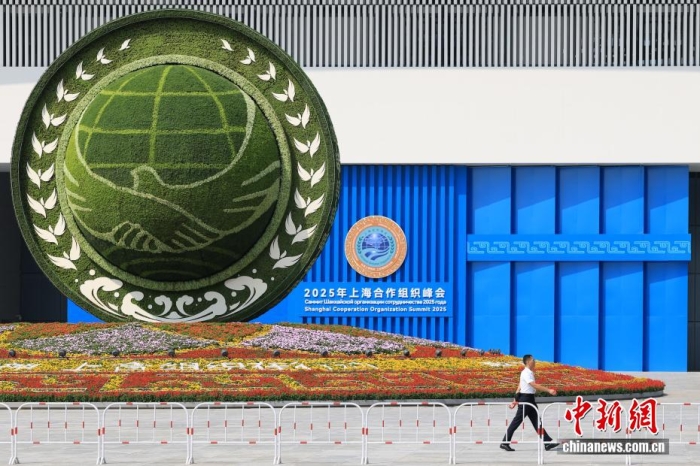 8月31日，天津，一名工作人員從2025年上海合作組織峰會主會場外的景觀花壇旁經過。當日，2025年上海合作組織峰會在天津舉行。<a target='_blank' href='/'><p  align=