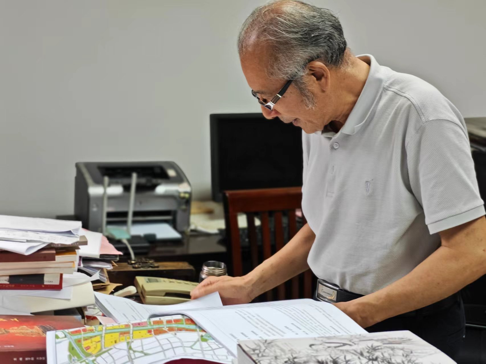 顧風(fēng)在辦公室翻閱資料。人民網(wǎng)記者 黃鈺攝