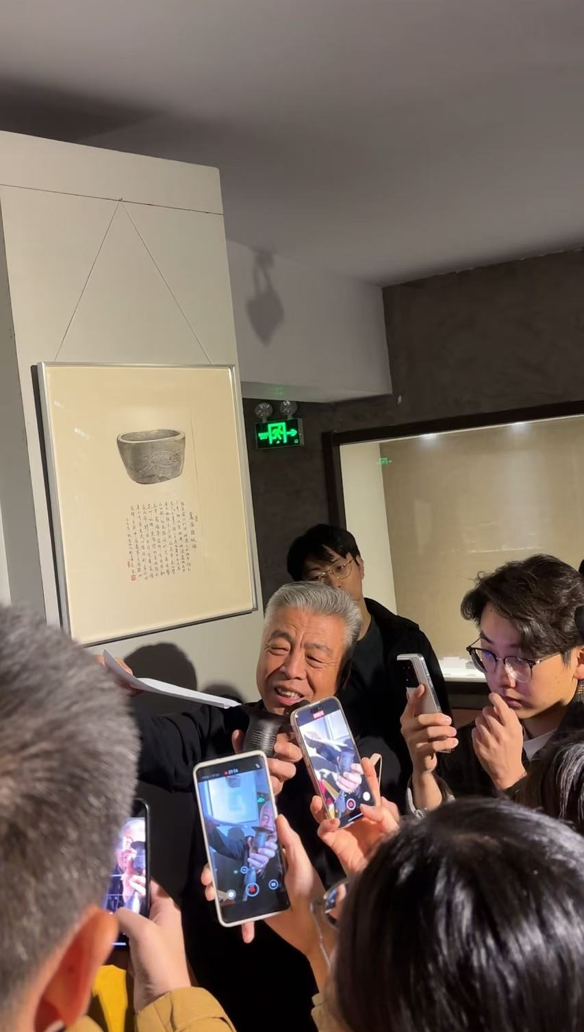 黑陶邢文化博物館館長邢葆東展示兩張相疊的A4紙，向記者解釋此為杯口的厚度。