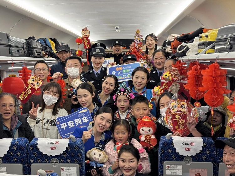 春節(jié)期間，在中老鐵路磨萬（磨丁—萬象）段，鐵路客運員工與乘客合影留念。李加勇攝