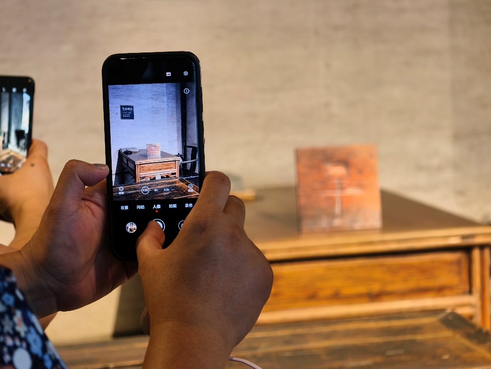 2025年7月15日，暑期研學(xué)團(tuán)小朋友在浙江省紹興市三味書屋拍攝魯迅讀書座位及課桌上的“早”字。受訪者供圖