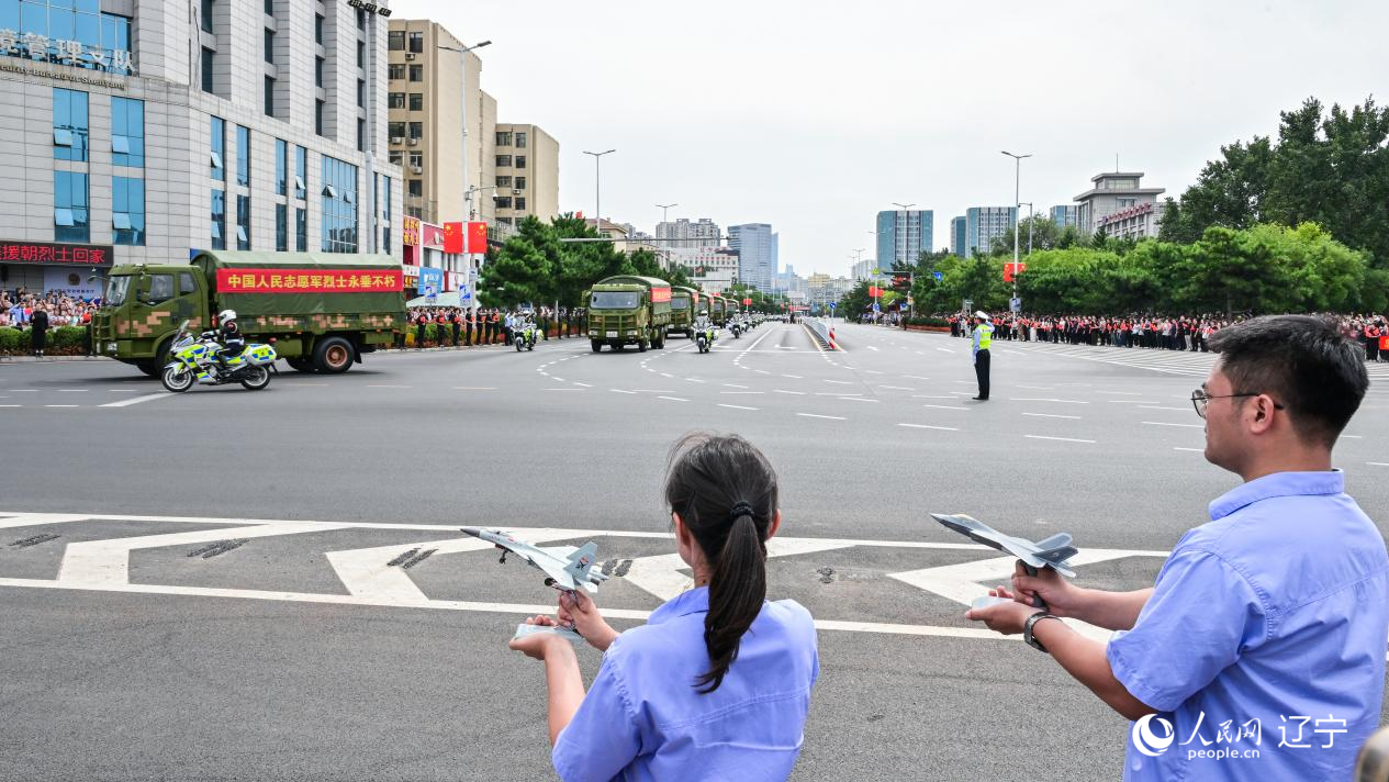航空工業(yè)沈飛的青年技術人員拿著受閱戰(zhàn)機的模型迎接烈士遺骸。航空工業(yè)沈飛供圖