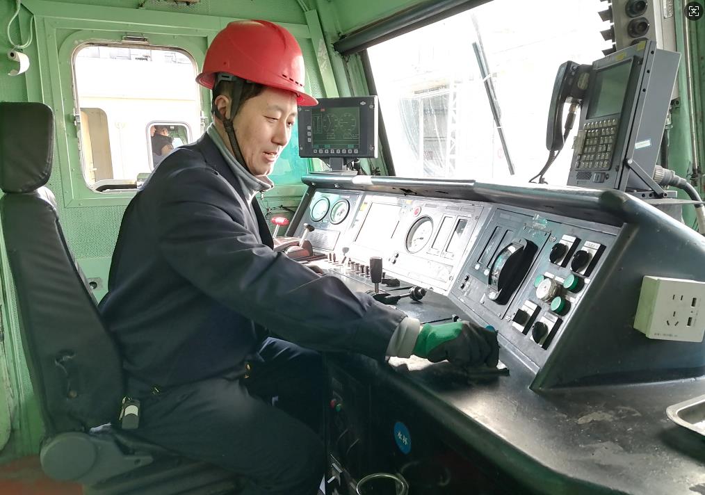 韓文盛正在檢查司機室操作臺。張秋生 攝