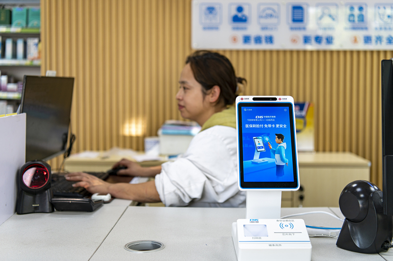 2024年4月10日，浙江金華市區(qū)一家民眾大藥房柜臺(tái)上設(shè)置著醫(yī)?！八⒛樦Ц丁睓C(jī)器，群眾看病更加便利。