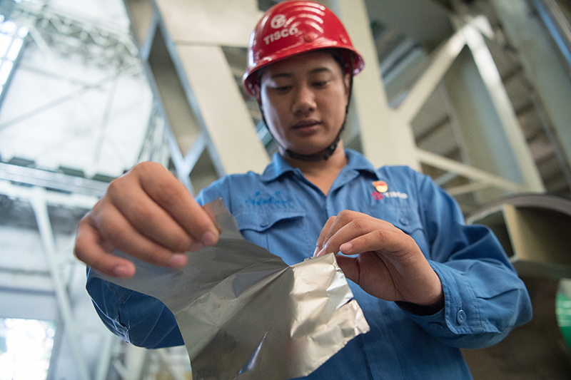 2018年8月8日，山西省太原市，太鋼精密帶鋼公司工作人員用手撕開不銹鋼。