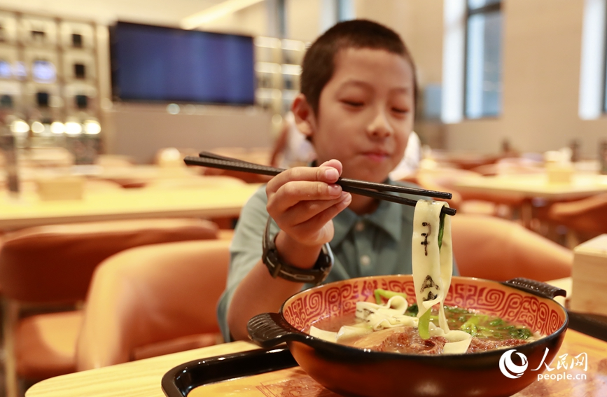 殷墟博物館推出的甲骨文面深受游客喜愛。人民網(wǎng)記者 慎志遠(yuǎn) 攝