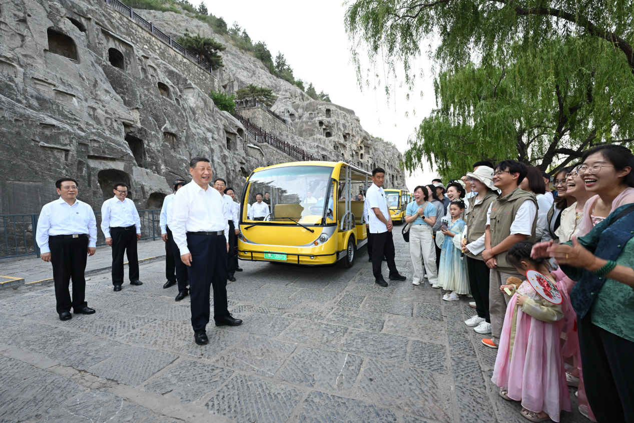 5月19日，習近平在洛陽龍門石窟考察時，同游客親切交流。