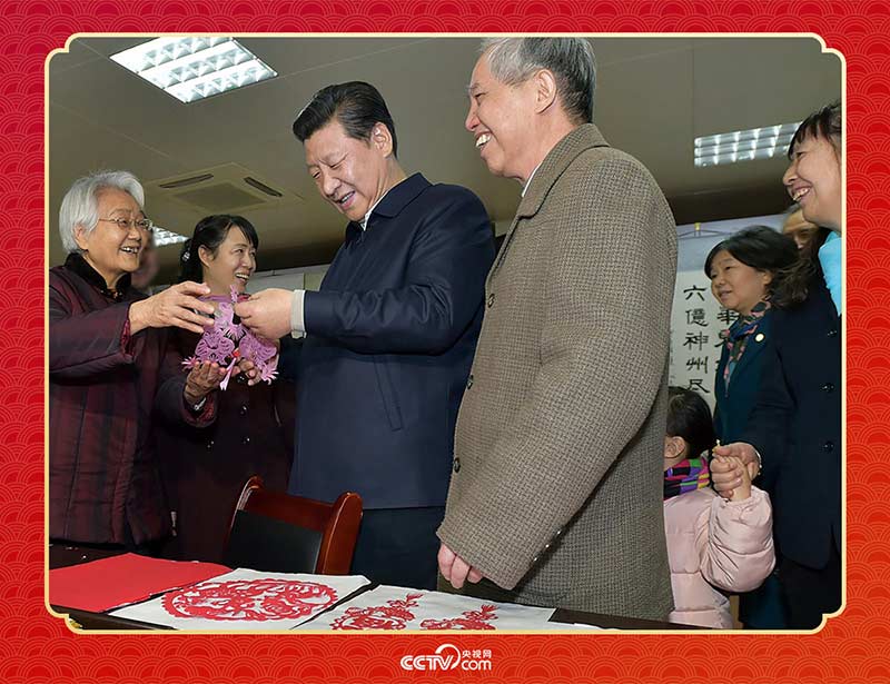 2015年2月15日，習近平在西安市雁塔區(qū)電子城街道二〇五所社區(qū)服務中心欣賞社區(qū)居民的剪紙作品。