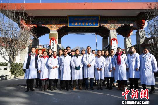 圖為該校師生在更名后的西藏藏醫(yī)藥大學(xué)校門前合影留念。　何蓬磊 攝