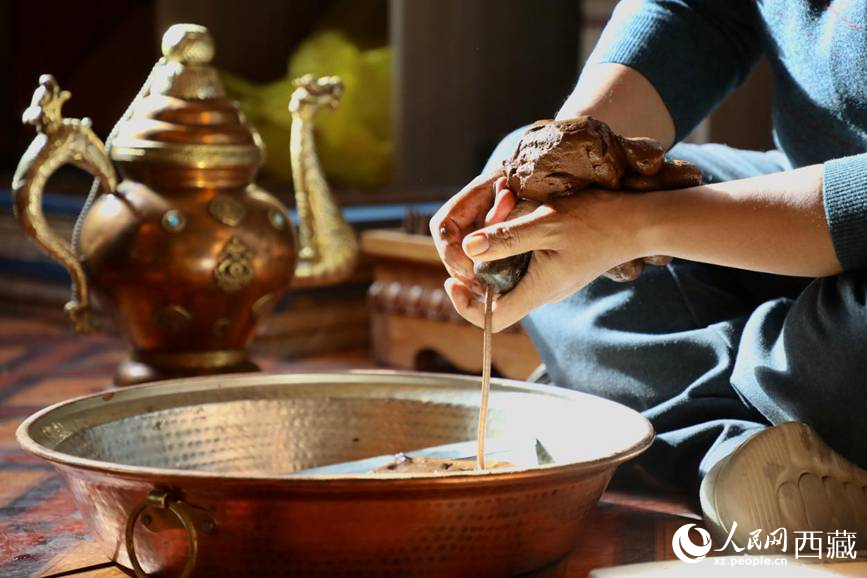 牛角鉆孔，將木泥擠出。人民網(wǎng)記者 次仁羅布攝