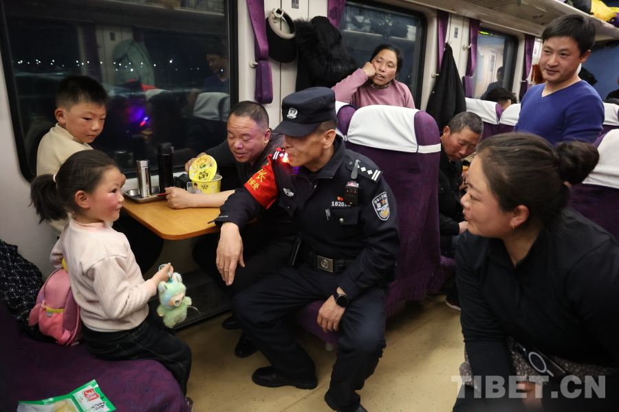 乘警長左紅彬在巡視車廂間隙，向攜帶兒童的旅客專門叮囑安全注意事項。.JPG