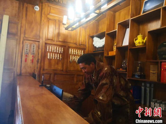 圖為桑杰才讓用電腦處理財務(wù)?！∈缝o靜 攝