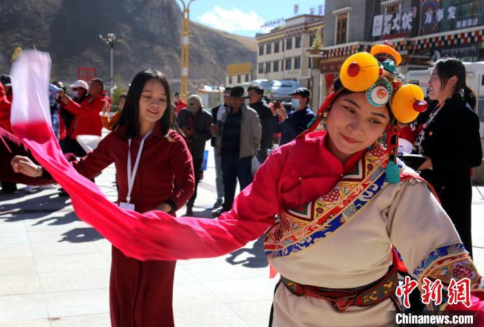 圖為中外記者向當?shù)孛癖妼W習民族歌舞文化?！?zhí)砀?攝