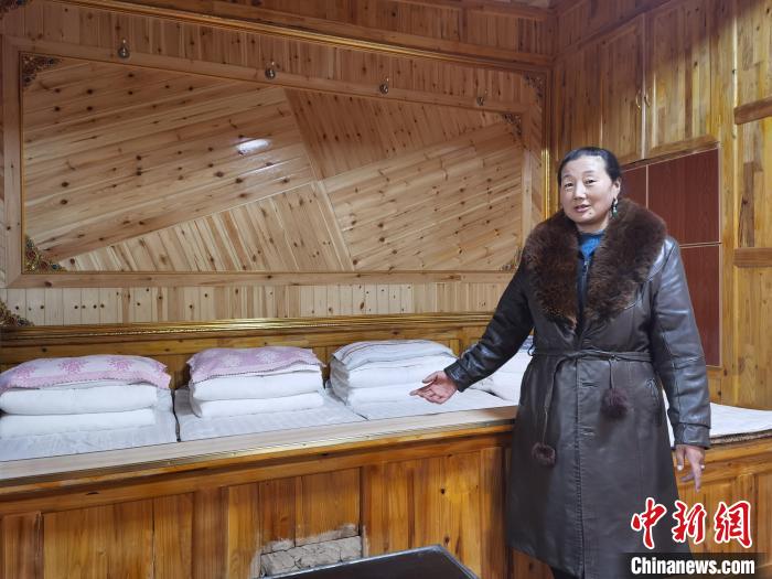 圖為德吉村村民鬧尖措介紹自家農(nóng)家樂?！∑钤鲚?攝