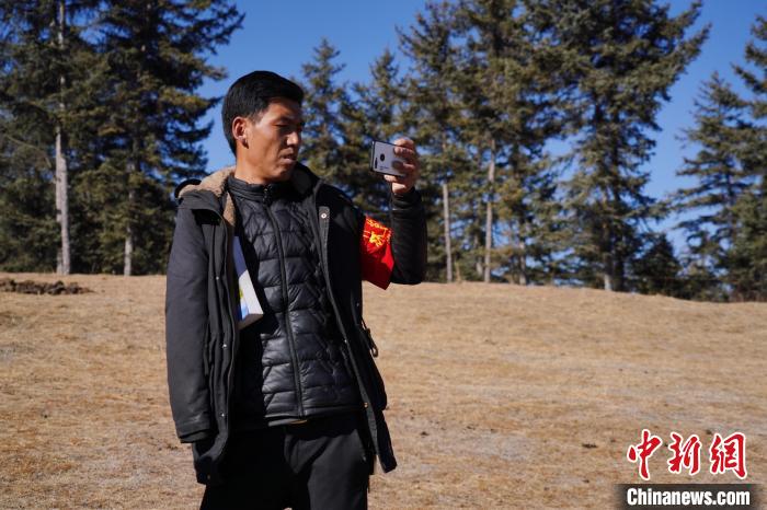 圖為桑杰加進行巡查并拍照記錄。　馬銘言 攝