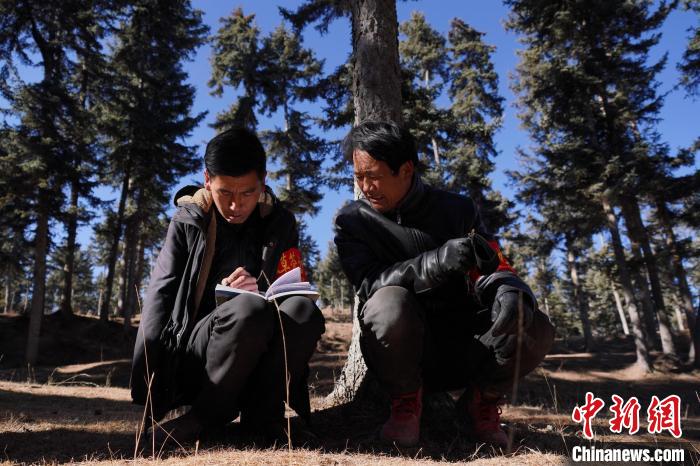 圖為桑杰加(左)和同事記錄巡查結果。　馬銘言 攝