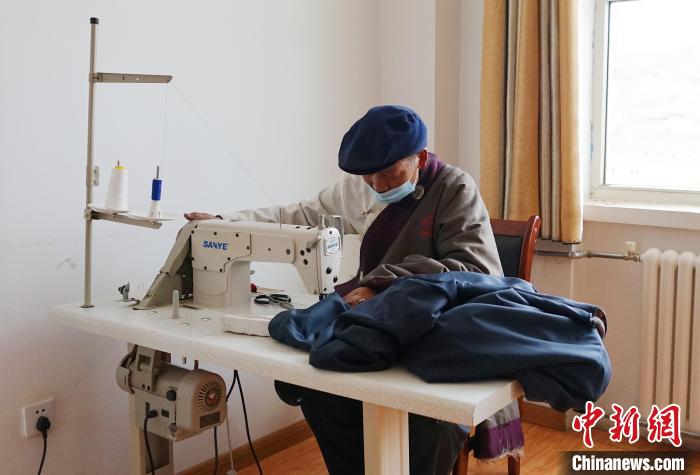 圖為敬老院老人使用縫紉機(jī)?！●R銘言 攝