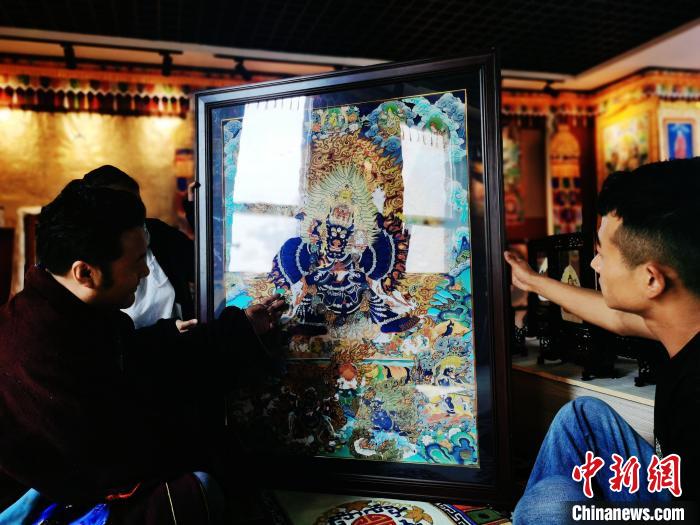 圖為久美尖措(左)與徒弟們展示唐卡作品。　張?zhí)砀?攝