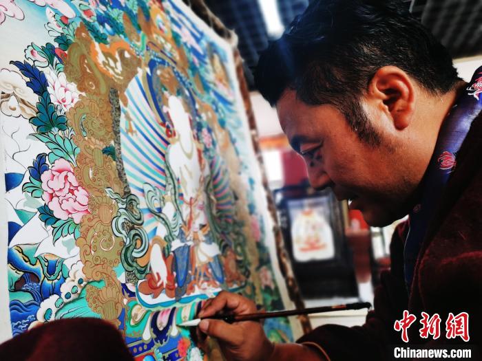 圖為久美尖措創(chuàng)作唐卡。　張?zhí)砀?攝