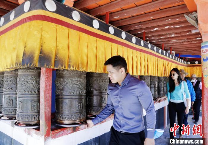 圖為外籍嘉賓體驗(yàn)藏族傳統(tǒng)轉(zhuǎn)經(jīng)筒?！●R銘言 攝