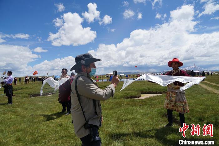 圖為一名外籍?dāng)z影師記錄當(dāng)?shù)夭刈鍤g迎儀式?！●R銘言 攝