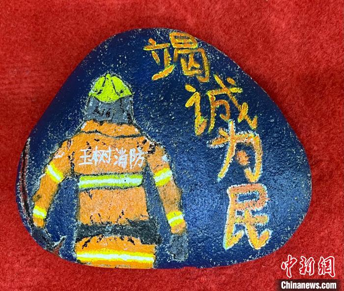 圖為玉樹(shù)消防指戰(zhàn)員創(chuàng)作的石頭畫作品《逆行在路上》?！O瑞祥 攝