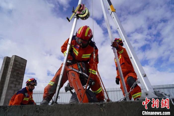 圖為地震實戰(zhàn)拉動現(xiàn)場，參演人員正在進行垂直救援項目?！∮駱湎拦﹫D