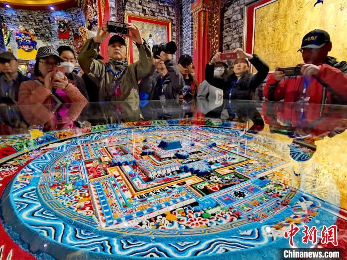 圖為參觀者拍攝壇城?！?zhí)砀?攝