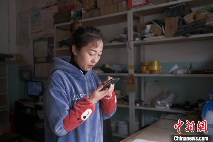 正在快遞站點內(nèi)忙碌的楊莉春?！『闻罾?攝