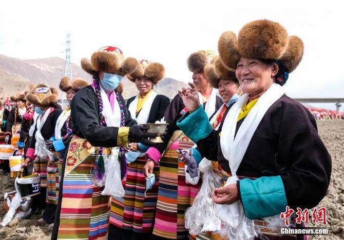 資料圖：西藏自治區(qū)拉薩市曲水縣才納鄉(xiāng)協(xié)榮村參加春耕儀式的村民互敬青稞酒。按照傳統(tǒng)，當(dāng)?shù)卮迕裆碇?jié)日盛裝，舉行隆重的儀式，祈福一年的豐收。<a target='_blank' ><p  align=