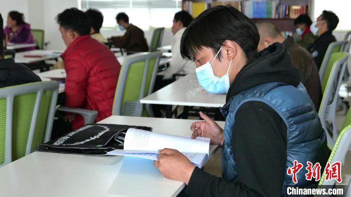 圖為正在閱讀“杰松達(dá)孜”藏歷法教材的學(xué)員?！≈x牧 攝