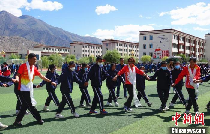 圖為世界冠軍與拉薩阿里地區(qū)高級中學學生一起跳鍋莊?！∪轿木?攝