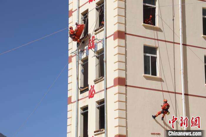 圖為消防指戰(zhàn)員進(jìn)行繩索救援演練。　朱科熹 攝