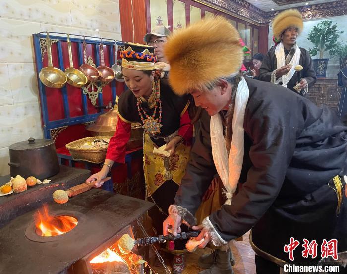 圖為人們在火上烤節(jié)日美食“結(jié)達(dá)”。　冉文娟 攝