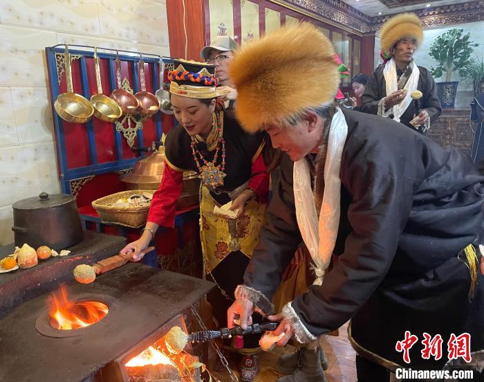 圖為人們?cè)诨鹕峡竟?jié)日美食“結(jié)達(dá)”?！∪轿木?攝