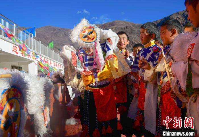 圖為加查縣安繞鎮(zhèn)小學(xué)學(xué)生在試穿藏戲面具?！∝暩聛硭?攝