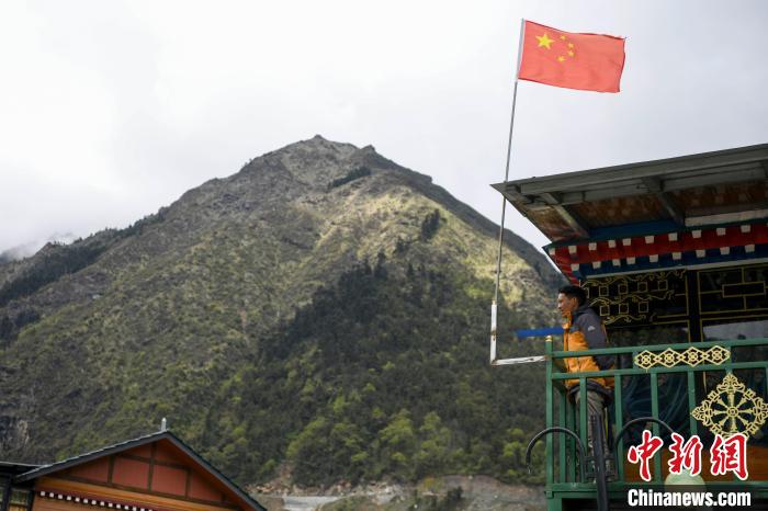 村民站在樓房上觀望。　楊華峰 攝