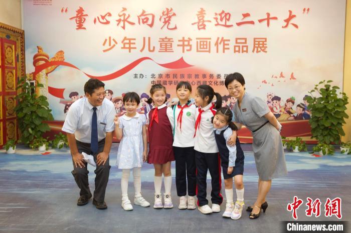 圖為與會嘉賓與入選畫作的“小作者”們在展覽上合影?！≈袊貙W(xué)研究中心供圖