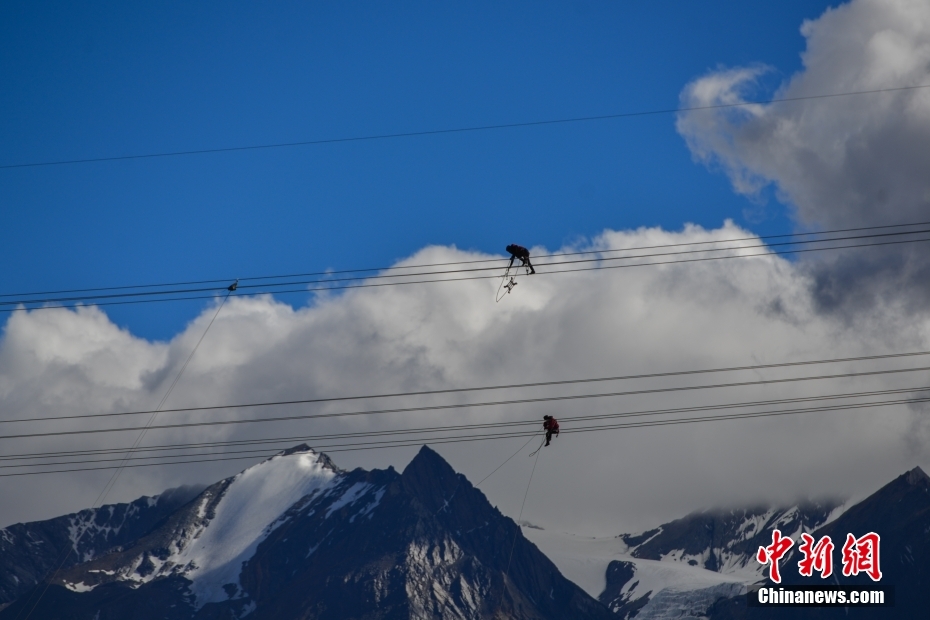 資料圖為2020年6月23日，西藏阿里聯(lián)網(wǎng)工程施工人員在日喀則希夏邦馬雪山附近進(jìn)行走線作業(yè)，安裝絕緣設(shè)備。 <a target='_blank' href='/'><p  align=