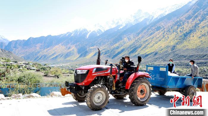 圖為工作人員將把加工完成的糌粑運(yùn)送至村民手中。　嘉黎縣融媒體中心供圖